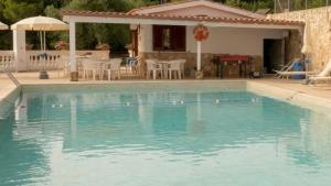 a swimming pool with blue water in front of a house at Residence Jolly in Peschici