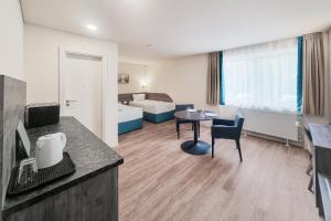 a living room with a room with a table and a bedroom at Terminal Park in Bischofsheim