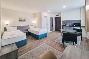 a hotel room with two beds and a table at Terminal Park in Bischofsheim
