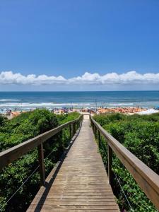 a wooden boardwalk leading to the beach at Palo Santo - Praia do Rosa in Praia do Rosa