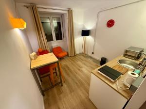 a small kitchen with a sink and a table at The Orange Teddy Bear Gijón in Gijón +15 photos
