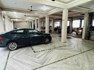 a car parked in a parking lot with a garage at Hotel Amrit in Bharwain