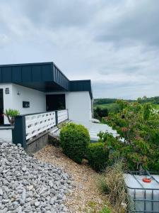 a house with a black roof and a rocky yard at Ferienidylle im Westerwald in Seck