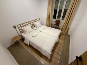 a bedroom with a white bed and a window at The Orange Teddy Bear Gijón in Gijón