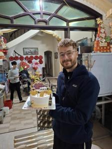 a man is holding a cake in a room at NinhBinh Central Homestay l Green Path in Xuân Sơn +20 photos