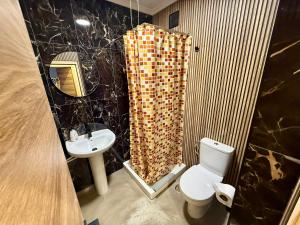 a bathroom with a sink and a toilet and a mirror at The Orange Teddy Bear Gijón in Gijón