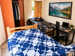 a room with a bed and a desk with a laptop at Apartamento FullLife in Zipaquirá