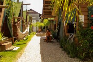 a woman sitting on a gravel path in an alley at Valhalla Glamping House in Bombinhas