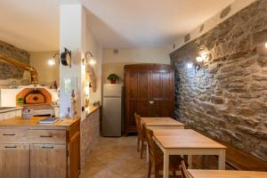 a kitchen with wooden tables and a refrigerator at Il Cortile di Mamma Mia in Pisano +34 photos