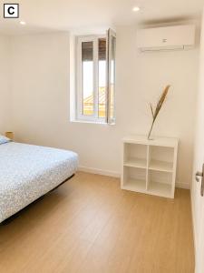 a white bedroom with a bed and a window at Notre Dame in Perpignan