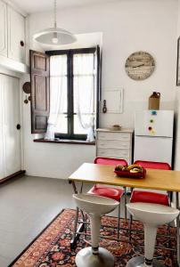 a kitchen with a table and chairs and a refrigerator at Guest House A Due Passi in Olbia +3 photos