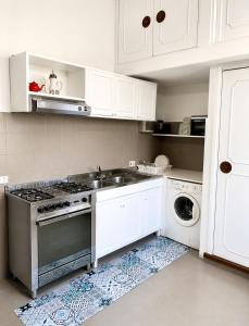 a kitchen with a sink and a stove top oven at Guest House A Due Passi in Olbia
