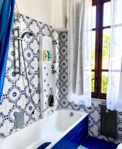 a bath tub in a bathroom with blue and white tiles at Guest House A Due Passi in Olbia
