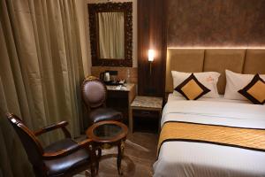 a hotel room with a bed and a chair at Florys Residency in Ooty