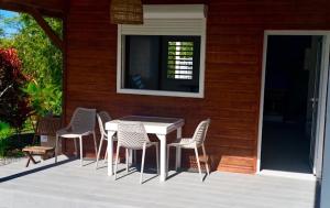 a patio with a table and chairs on a house at Cocon Kréyòl in Sainte-Anne