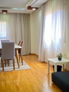 a living room with a table and a table and chairs at Golden Rose- men only in 6th Of October
