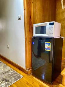 a microwave sitting on top of a refrigerator at Golden Rose- men only in 6th Of October