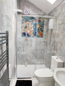 a bathroom with a shower with a toilet and a sink at New Studio Near Science Park Cambridge in Cambridge