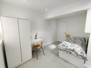 a white bedroom with a bed and a desk at New Studio Near Science Park Cambridge in Cambridge