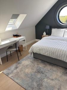a bedroom with a bed and a desk and a window at Beyren House Guest Suite in Emo