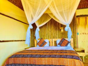 a bedroom with a large bed with a canopy at Bwindi Coffee Lodge in Kachulagenyi