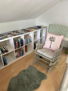 a living room with a chair and book shelves at Castle cottage in Cowbridge