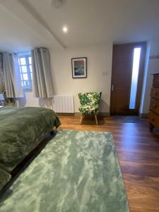 a bedroom with a bed and a chair and a door at Castle cottage in Cowbridge