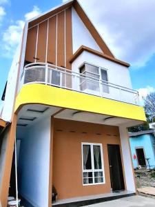 a view of a house with a balcony at Nok Homestay in Pangururan