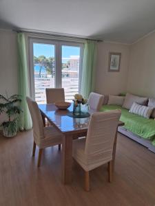 a dining room with a table and chairs and a couch at More in Vodice
