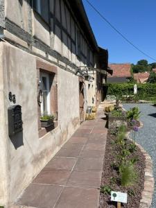 a walkway next to a building with plants on it at Gîte aux charmes d'Antan in Weinbourg +26 photos