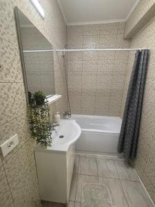 a bathroom with a white tub and a sink at Nolia Apartments in Bucharest +32 photos