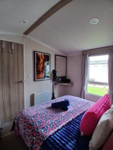 a bedroom with a bed with pink pillows and a window at 8 Moray View Seton Sands in Port Seton