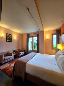 a bedroom with a large bed and a living room at Hôtel La Riviera Victoria in Yvoire