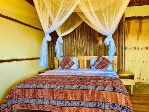 a bedroom with a bed with a canopy at Bwindi Coffee Lodge in Kachulagenyi