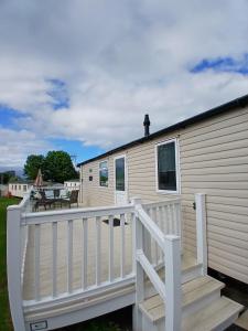 a mobile home with a porch and a deck at 8 Moray View Seton Sands in Port Seton