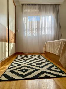 a room with a black and white rug in front of a window at Golden Rose- men only in 6th Of October