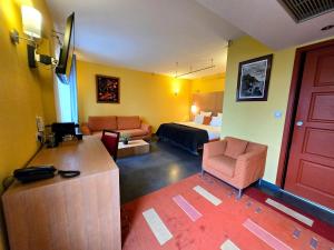 a room with a hotel room with a bed and a couch at Hôtel La Riviera Victoria in Yvoire