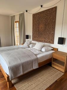 a bedroom with a bed with a large headboard at Milla - Exklusives Wohnen im Grünen in Cortaccia
