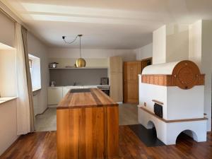 a kitchen with a wooden island in the middle of a room at Milla - Exklusives Wohnen im Grünen in Cortaccia