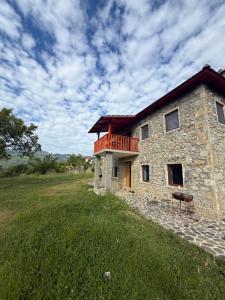 a building with a balcony on top of a field at Hasan Nika's Tower in Karicë