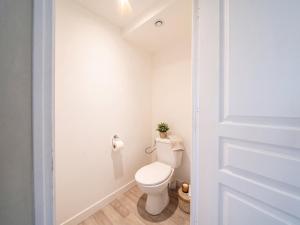 a bathroom with a toilet with a plant on the wall at Loft Spa lumineux Jacuzzi privé écran cinéma in Roubaix