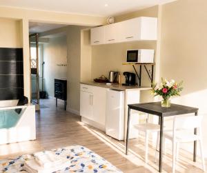 a kitchen with a table with a vase of flowers on it at Loft Spa lumineux Jacuzzi privé écran cinéma in Roubaix