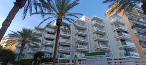 a large building with palm trees in front of it at El Yate Sol y Mar in Aguadulce