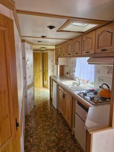 a kitchen with a sink and a stove top oven at Rodzinne Domki Łeba in Łeba