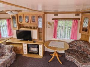 a living room with a couch and a table in a caravan at Rodzinne Domki Łeba in Łeba