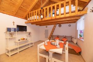 a living room with a loft bed and a table at Holiday Home Grubišić in Mirce