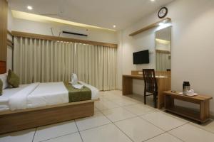 a bedroom with a bed and a desk and a television at Hotel Decent in Bhāndu