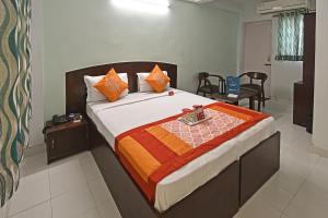 a bedroom with a large bed with orange and orange pillows at Hotel Gangotri in Haridwār