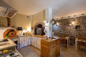 a kitchen with a counter and a stone wall at Il Cortile di Mamma Mia in Pisano
