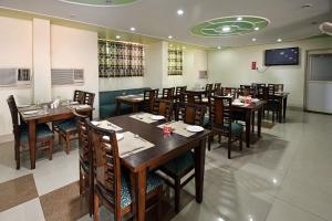 una sala da pranzo con tavoli e sedie in un ristorante di Hotel Gangotri a Haridwār